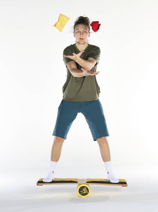 Throwing & catching advanced: The addition of the wobble board not only challenges the right and left hemispheres of the brain, but also the areas that supply the arms and legs.