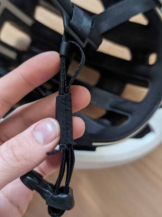 There is no long strap hanging around the chin strap, POC has solved this elegantly.