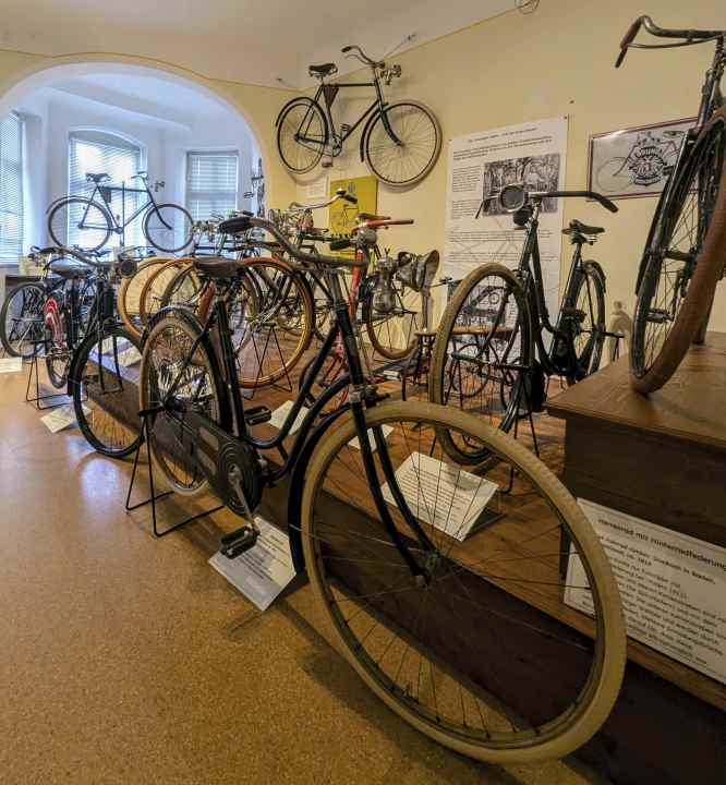This room contains bicycles from the 1920s, the time when the gear shift was invented and manufacturers began to produce bicycles from light metals. This was particularly important for the sport of racing cycling.