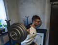 Squatting on an old carpet in front of potted plants and nylon curtains: "my training centre".