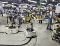 Chaîne de montage et colonne de robots. Pour qu'un vélo entièrement assemblé puisse être mis en boîte toutes les deux minutes, chaque geste doit être parfait.