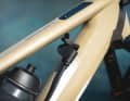 The range extender is plugged into the charging port of the e-bike using a cable.