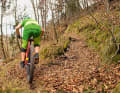 Rear wheel on the ground: As soon as the rear wheel has touched the ground, the momentum is usually gone. Therefore, bring your body forwards dynamically and pedal quickly to pick up speed again. | FALSE: The centre of gravity is still too far to the outside when setting off, resulting in an emergency exit to the left

 Tip from riding technique expert Stefan Herrmann: "The manoeuvre requires some practice. You have to do three things at the same time. Firstly: scan the bend and brake. Secondly, take the weight off the rear wheel. Thirdly: perform the manoeuvre with a hip swing. Tip - film yourself"