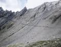 And suddenly this wave of spray solidified into rock stands before you: the 2936 metre high Col Malatrà. A rope helps you through the gap in the rock for the last 70 metres.