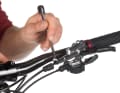 Remove the protective cap to access the fastening screws. Then loosen the fastening screw with an 8 mm open-end spanner.