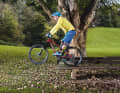 4. safely down

 Stefan still has enough momentum to use the drop technique. To do this, he stretches his legs and arms dynamically as soon as his front wheel is about to leave the park bench. The result: his centre of gravity shifts backwards - he lands with both wheels at the same time.
