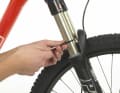 1. Binden Sie einen Kabelbinder um einen der Gabelholme. Der Kabelbinder erfüllt die gleiche Funktion wie der Gummiring am Dämpfer: als Markierung, um den Negativ-Federweg (Sag) zu bestimmen.