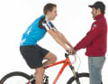 2. Setzen Sie sich in zentraler Position auf Ihr Bike, so dass der Druck auf Sattel und Lenker lastet. So messen Sie, wie weit die Gabel einfedert. Eine zweite Person sollte das Bike dabei halten.

3. Durch Ihr Gewicht rutscht der Kabelbinder am Gabelholm nach oben und zeigt den Negativ-Federweg (Sag) an – der Federweg, um den die Gabel ausfedert, wenn Sie z.B. eine Stufe hinunter fahren.