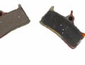 3. glazed brake pads: You will need sandpaper* with a grit of 100-150 (printed on the back of the paper, available from DIY stores). Place the paper on a flat surface and briefly rub the pads evenly over the paper. You have done everything right if the coverings are no longer shiny, but matt and slightly rough, like the left covering in the picture. 