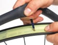 Vorbereitung: Zuerst muss die Felge, wie bei jeder Tubeless-Umrüstung, mit einem Hochdruck-Dicht-Tape luftdicht abgeklebt werden. Dann noch das Ventilloch durchstechen und los geht’s.