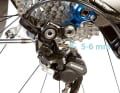 Use the B-screw to adjust how far the rear derailleur wraps around the cassette. The distance between the guide roller and the large sprocket should be 5-6 millimetres.