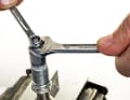 Nachdem Sie die Achse gesäubert haben, können Sie das Lagerspiel mit 10er- und 7er-Maulschlüssel oder dem Shimano-Konuswerkzeug neu einstellen.