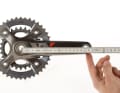 KURBELLÄNGE
Kleine Leute, kleiner Rahmen: Auch die Kurbellänge sollte angepasst werden.

Gemessen wird die Kurbellänge von der Mitte der Tretlagerachse bis zur Mitte der Pedalachse. Am häufigsten sind 175-mm-Kurbeln verbaut, gefolgt von 170ern. Hochwertige Kurbelsysteme, wie die XTR-Kurbeln, bietet Shimano in 2,5-mm-Schritten an.
Kürzer oder Länger? Einflussfaktoren auf die optimale Länge gibt es viele: Körpergröße, Schrittlänge, Vorlieben. Falls Sie nicht mit der Standard-Kurbel zurechtkommen, sollten Sie etwas unternehmen. Dabei gilt: Große (ab 1,90 m) und sportliche Fahrer greifen zur längeren Kurbel, kleine (unter 1,70 m) und mit hoher Trittfrequenz kurbelnde Biker wählen die kürzere Variante.
Bei Knieproblemen sollten Sie kürzere Kurbeln ausprobieren, da so der Bewegungsumfang verringert wird. Fahrer, die gern mit dicken Gängen und niedriger Trittfrequenz in die Pedale treten, sind mit längeren Kurbeln besser beraten, weil die Umlaufstrecke dadurch zunimmt. Nach dem Umstieg aktivieren Sie ungewohnte Muskelbereiche: also langsam beginnen!