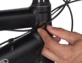The brake line should be routed in an evenly curved bend along the fork bridge to the rear of the immersion tube. The cables must be long enough to allow full steering lock on both sides. This is also how to find the position for the rubber pads and shift cable protection: clean the area thoroughly. With the handlebars folded in, attach the adhesive pad in the centre under the cable - done