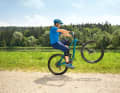 Correct wheelie - 2: From the crouched push-up position, lean backwards by stretching your arms. At the same time, you pedal powerfully. Result: The front wheel lifts off and your centre of gravity moves into the so-called "sweet spot". Caution: This is further back than most people think. Now you must continue to pedal steadily. Remember: Always (!) keep your arms straight.