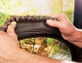 Now grip the tyre with both thumbs on the tread and with your index fingers on the sidewall. Lift the tyre over the rim flange. Just a little bit is enough to push the tyre down over the rim with a little bit of force.
