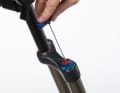 Unscrew the adjustment caps: Fully open the rebound damping (red adjustment wheel). Unscrew the adjustment knob using a 2-millimetre Allen key.