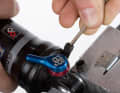 Release the air: Use a small Allen key (2 mm) to press the pin in the valve down until no more air escapes. Compress the damper a few times and repeat the process two more times.