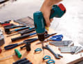 Put the tools to one side and place the screws on the markings. If you then hang the tools back again, you can screw in the screw to the correct depth.