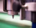 Ein Cutter saust millimetergenau über die Carbon-Matte und schneidet sämtliche Einzelteile in der passenden Faserrichtung aus. Das Programm verteilt die einzelnen Bauteile so auf der Matte, dass möglichst wenig Verschnitt entsteht.