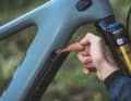 Löst man für die Akku-Entnahme das Cover vom Unterrohr des Yeti 160E T1, wird ein kleiner Spalt frei, um den Akku an einer Klinke für die Entnahme zu entsichern. Biker ohne Spinnenfinger gelangen nur mit Nachdruck an den Sicherungshaken.