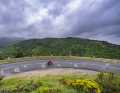 The storm clouds hang ominously over the Parc naturel régional des Monts d'Ardèche. The road leads away from the river past chestnut forests typical of the region.