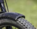 There is not enough space between the tyre and mudguard. Small stones are constantly clattering in between.