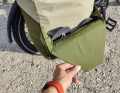 There should be room for a helmet behind the flap that holds the roll-top fastener. However, if the Deuter Xberg is well filled, only sandals will fit inside.