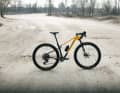 The bike combines a carbon frame with integrated rear suspension and a 100 mm suspension fork.