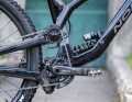As the name suggests, the main pivot point on a high-pivot bike like the Norco Range is not located near the bottom bracket as usual, but much higher up. This increases the distance between the bottom bracket and the rear wheel axle during compression, which means that the rear wheel swerves backwards to avoid the obstacle instead of getting "stuck" on it. The disadvantage: The longer the chainstay length, the more the chain pulls the chainring back during compression. Depending on the chain tension, this leads to negative effects on the chassis and pedal kickback. To decouple the chassis from these drive influences, the chain runs over a pulley near the pivot point.