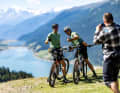 Even the racers of the BIKE Transalp 2023 stopped for a photo at the view of Lake Reschen from the Plamort plateau.