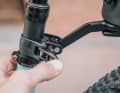 La tige de selle est également équipée d'un système de serrage rapide. Un revêtement en caoutchouc protège la tige, tandis qu'un petit levier permet de tendre la sangle de serrage. Ce système s'adapte à tous les diamètres de tige courants. Photo : Stefan Frey