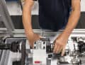 Full control: Each finished gearbox (here in the employee's right hand) undergoes numerous gear and load changes in a high-tech testing machine. In the past, the gearboxes were mounted in a bicycle on a training roller for practical testing.