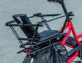 Child seat with cage: The railing as well as textile footrests and a spoke guard ensure safe transport.