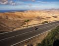 Rennradfahrer auf  schmaler Bergstraße nahe des
Aussichtspunkts Mirador de Guise y Ayose, Blick nach Norden in Richtung Valle de Santa Inés, Kanarische Inseln, Spanien