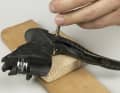 2. place the lever on a drilled wooden strip or a plastic-protected vice - the side without the operating lever on top. The retaining bolt of the brake lever lies over the hole or can slide through between the vice jaws.