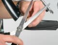 5. Schneiden Sie von einem abgefahrenen Reifen ein rund zehn Zentimeter langes Stück ab. Markieren Sie die gewünschten Löcher im Reifen. Falten Sie den Reifen genau an der markierten Stelle über Kreuz und schneiden Sie mit der Schere die Ecken ab – fertig sind die Befestigungslöcher.