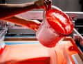 From above, a worker pours paint into the press, which hits the blank