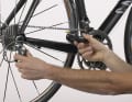 3. si la butée extérieure est correcte, vérifiez la butée intérieure. Tournez lentement la manivelle et, de l'autre main, poussez doucement le dérailleur vers l'intérieur jusqu'à ce que la chaîne soit remontée jusqu'au plus grand pignon. Dans cette position, le dérailleur ne doit pas pouvoir être poussé plus loin vers l'intérieur, sinon la chaîne peut se retrouver entre la couronne et les rayons, ou la cage du dérailleur peut entrer en collision avec les rayons. Ces deux situations peuvent entraîner des chutes et de graves dommages.