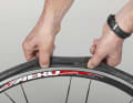 1. unscrew the valve cap, open the knurled nut at the top of the valve and press it into the valve body until the air has completely escaped. Press both sides of the tyre cover together over the entire circumference of the wheel so that the tyre foot is in the deepest part of the rim well.