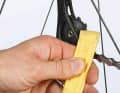 2. use a cloth to remove freshly deposited lubricant sludge from the shifting rollers. If the oil has hardened, you can use a plastic tyre lever, for example, to plane it off. Apply the "tyre lever" and turn the crank backwards. Wipe the rest of the rear derailleur clean as well.