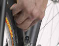 3. check the position of the inner guide plate in relation to the chain. The chain should not graze, but the distance must be as small as possible. Adjust the distance using the internal end stop screw. As this is usually difficult to turn due to the front derailleur being on top, you should relieve the screw by swivelling the front derailleur cage slightly outwards by hand. Screw in the end stop gradually and keep turning the crank in between until the distance is correct. Check that the cable tension screw on the down tube or head tube is fully screwed in and that the shifter is relaxed before checking that the cable is taut. It should be virtually impossible to pull the cable away from the down tube before the derailleur starts to move.