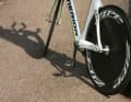 Appuie la roue arrière contre le poteau. Le frottement du pneu évite que le vélo de course ne se mette à rouler et à basculer. Les mécaniciens professionnels rangent ainsi toute une série de machines de course dans un espace restreint, contre le mur d'une maison.