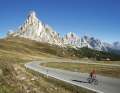 Panoramic view: Ra Gusela (2595 m) rises like a finger pointing above the Passo di Giau (2236 m), with the peaks of the Tofane rising into the blue sky to the right.