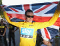 Bradley Wiggins feiert mit der britischen Flagge den Sieg bei der Tour de France 2012.