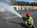 The temperature is around 36°C. The drivers gladly accept the cooling from the fire brigade