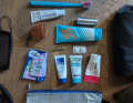 Le sac à dents contient aussi une crème pour le siège, une coupe menstruelle, une crème solaire, une pince à épiler, de l'ibuprofène et des lingettes humides.