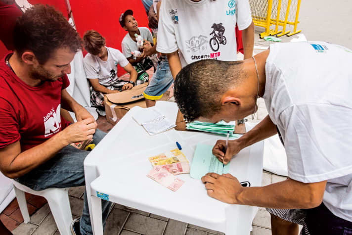   Rennchef Thiago Gomes (rotes Shirt) bringt nicht nur Stimmung, sondern auch Geld in die Fevelas.