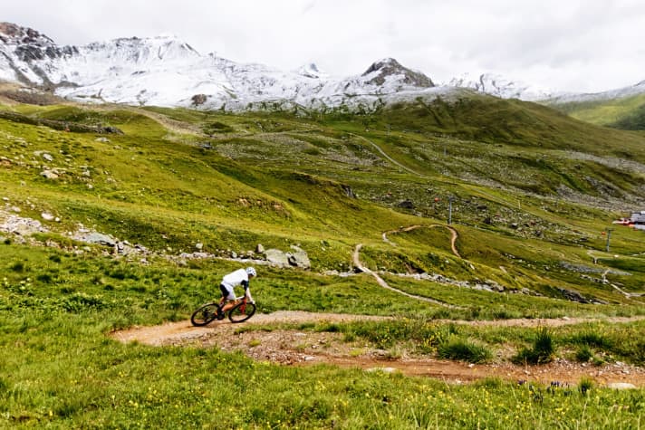   Im Angesicht der Silvretta: Der angelegte Singletrail nach Samnaun windet sich durch blühende Bergwiesen.