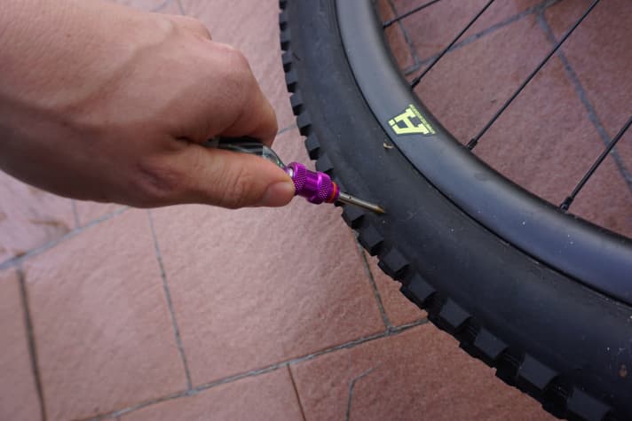   Schritt 1: Einfach den Stachel mit dem eingeführten Gummiflicken und der aufgedrehten Kartusche durch das Loch im Reifen stoßen.
